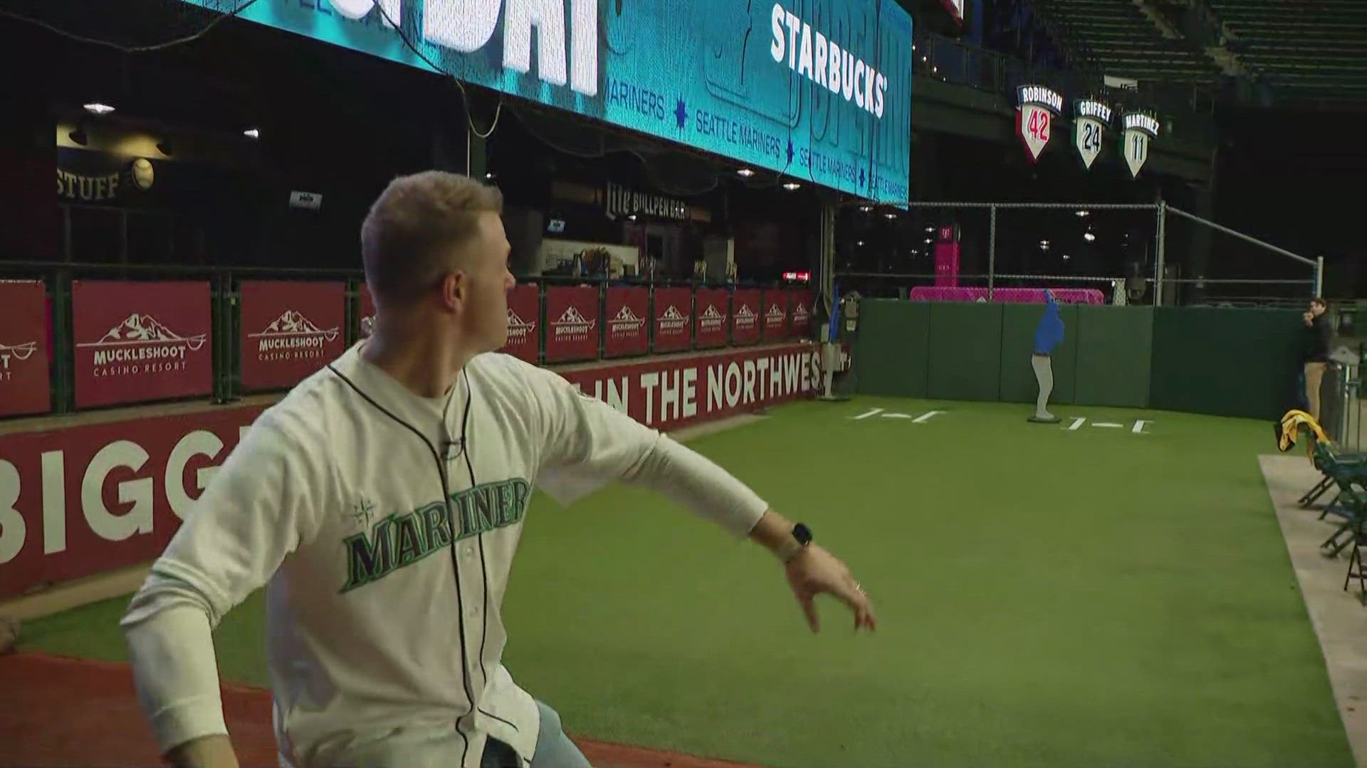A Seattle Mariners relief pitcher warms up on the mound during a night game as a bullpen catcher sets the target