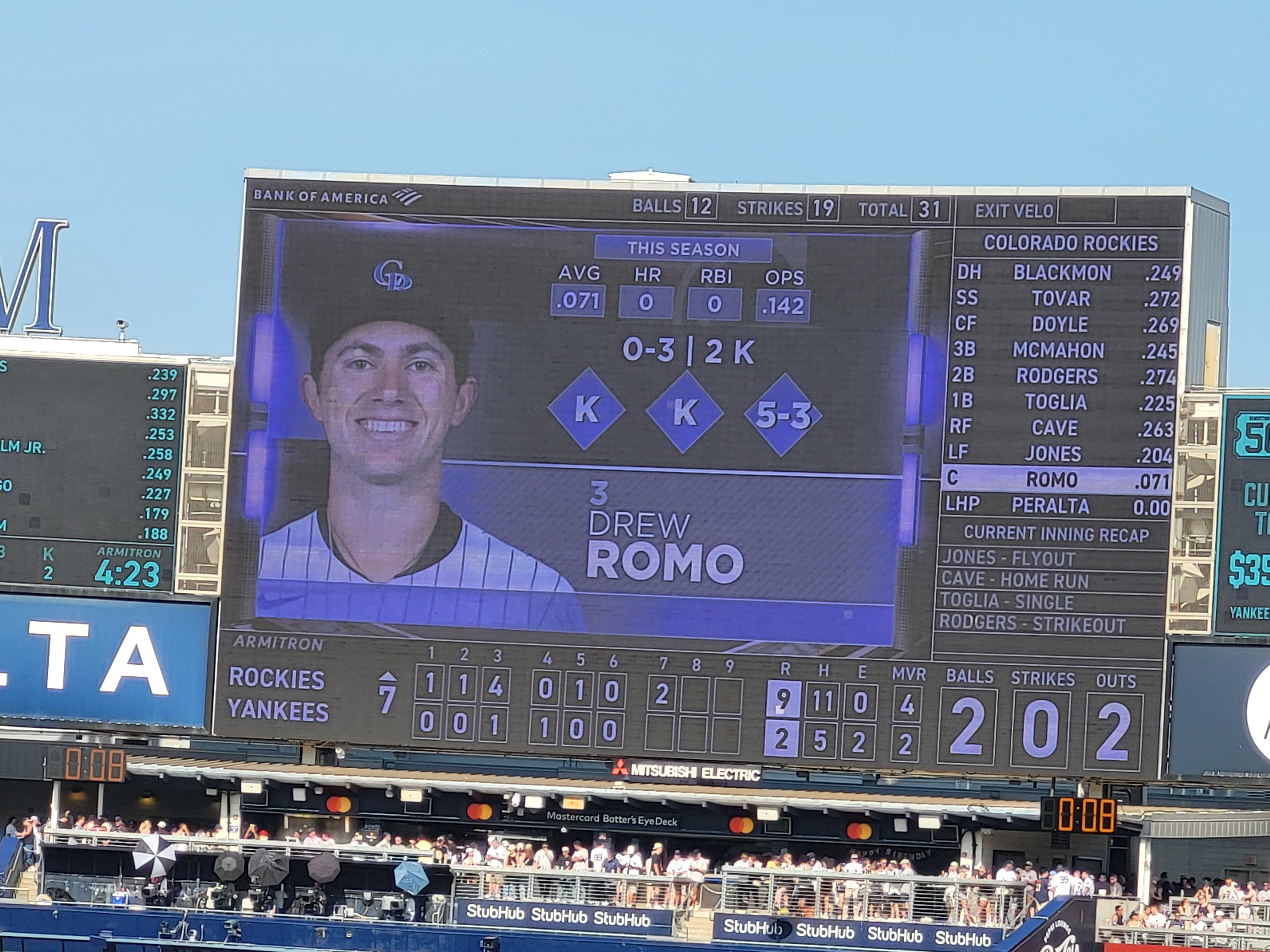 A baseball stadium scoreboard showing a close game late in the innings.