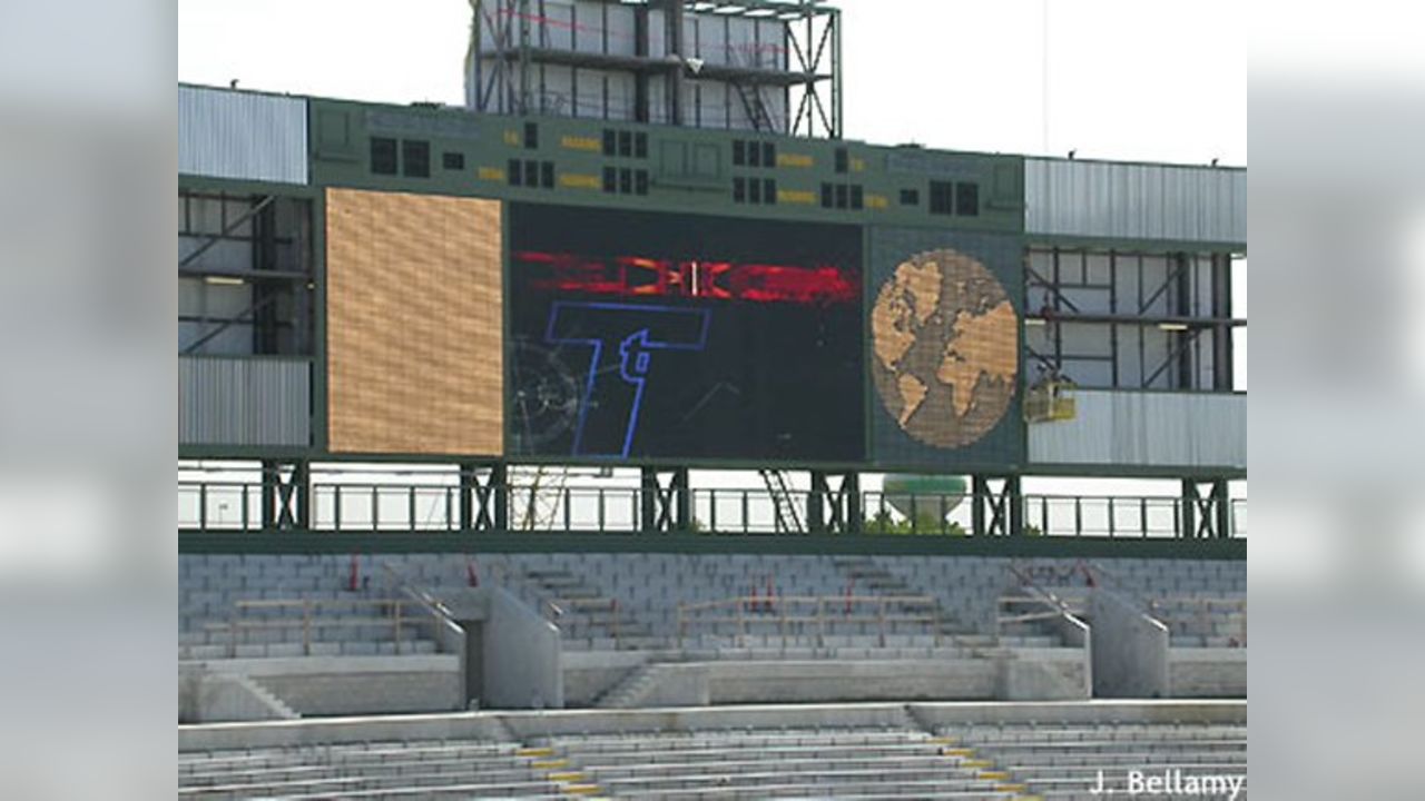 A large stadium scoreboard lit up at night, evoking the idea of constant score checking and refresh behavior as investors watch quotes