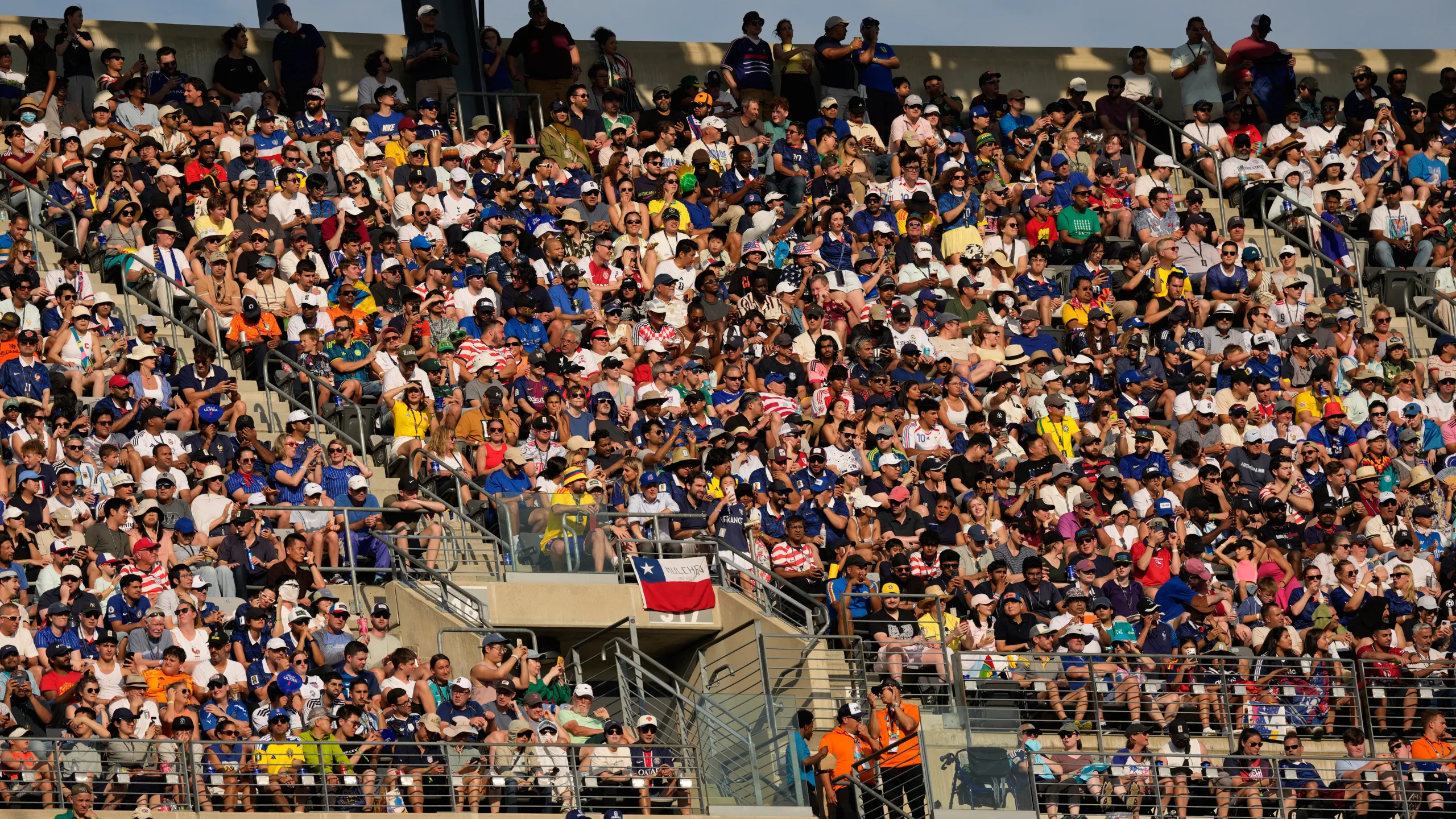 A packed crowd at Target Field reacting to a big late-inning play, fans standing and cheering with the infield visible in the distance
