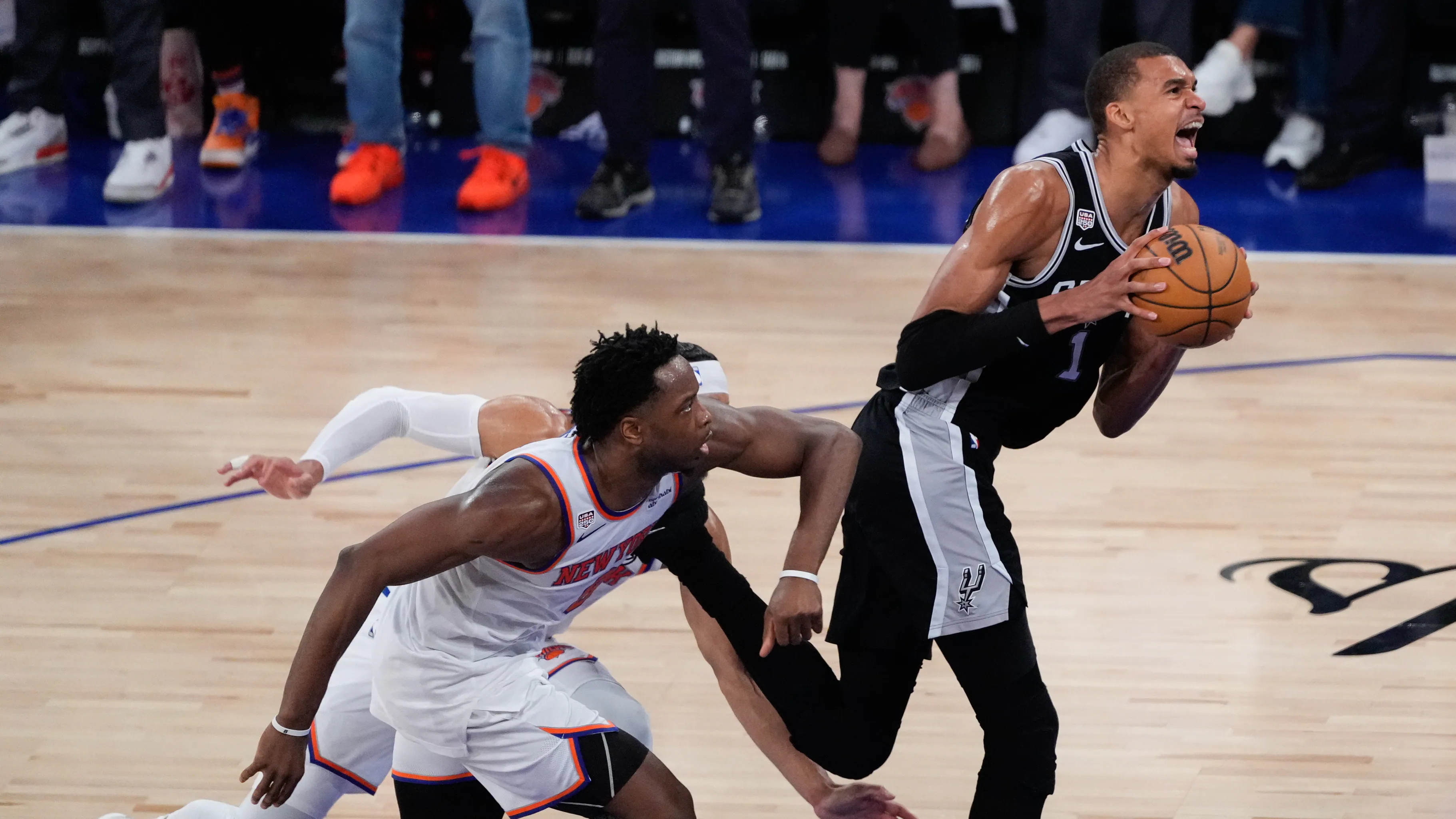 A player at the free throw line in a tense late-game moment with teammates lined up on the lane and the crowd focused behind the basket