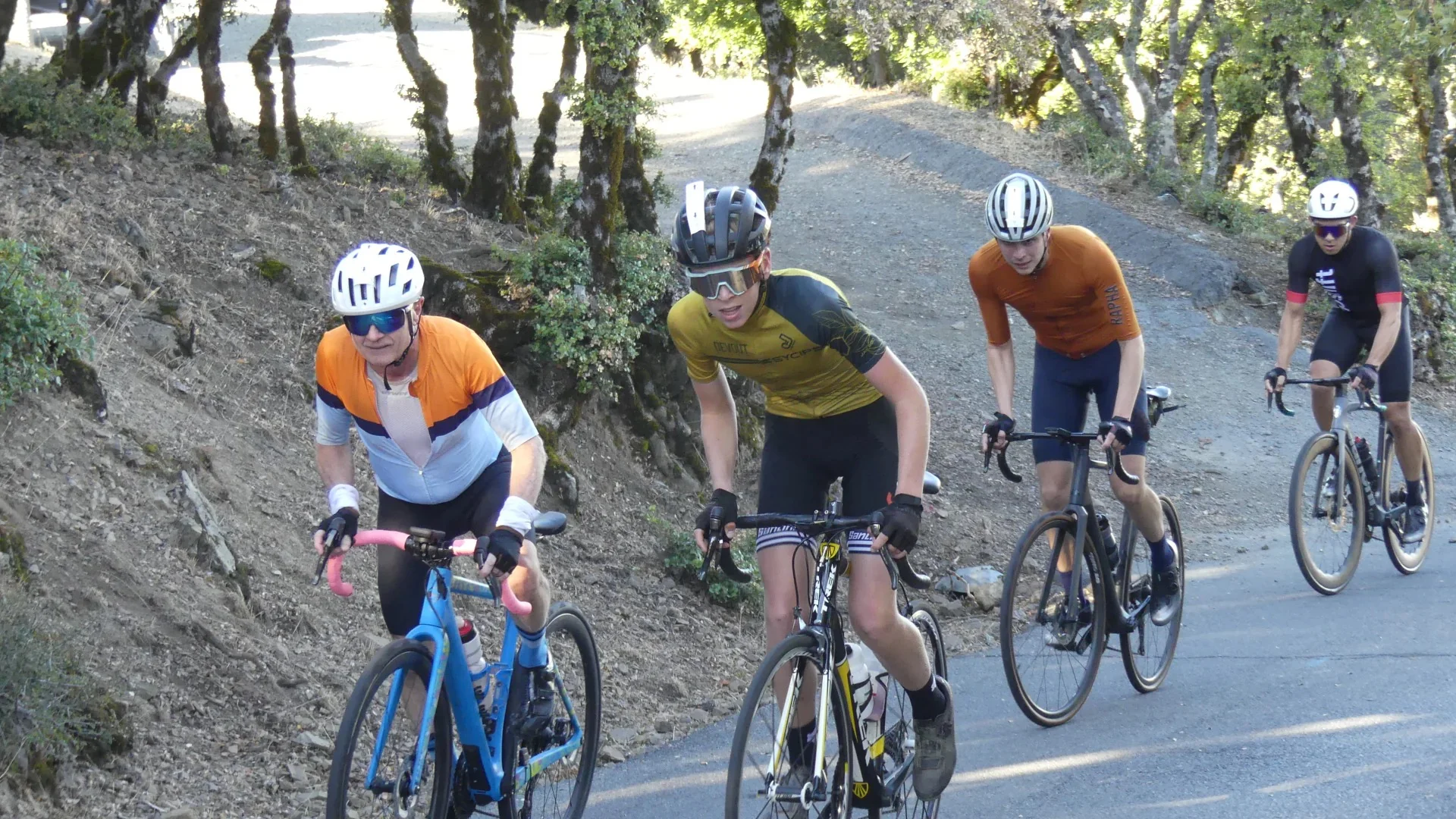 A rider in a weekend group ride rolling on an aluminum road bike on a smooth suburban road