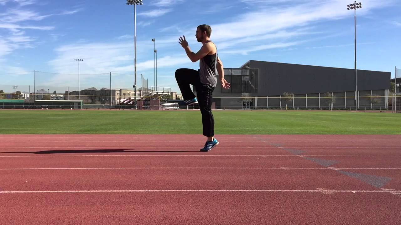 A track athlete performing A-skip drills on a straightaway, with upright posture, active arm swing, and toes pulled up