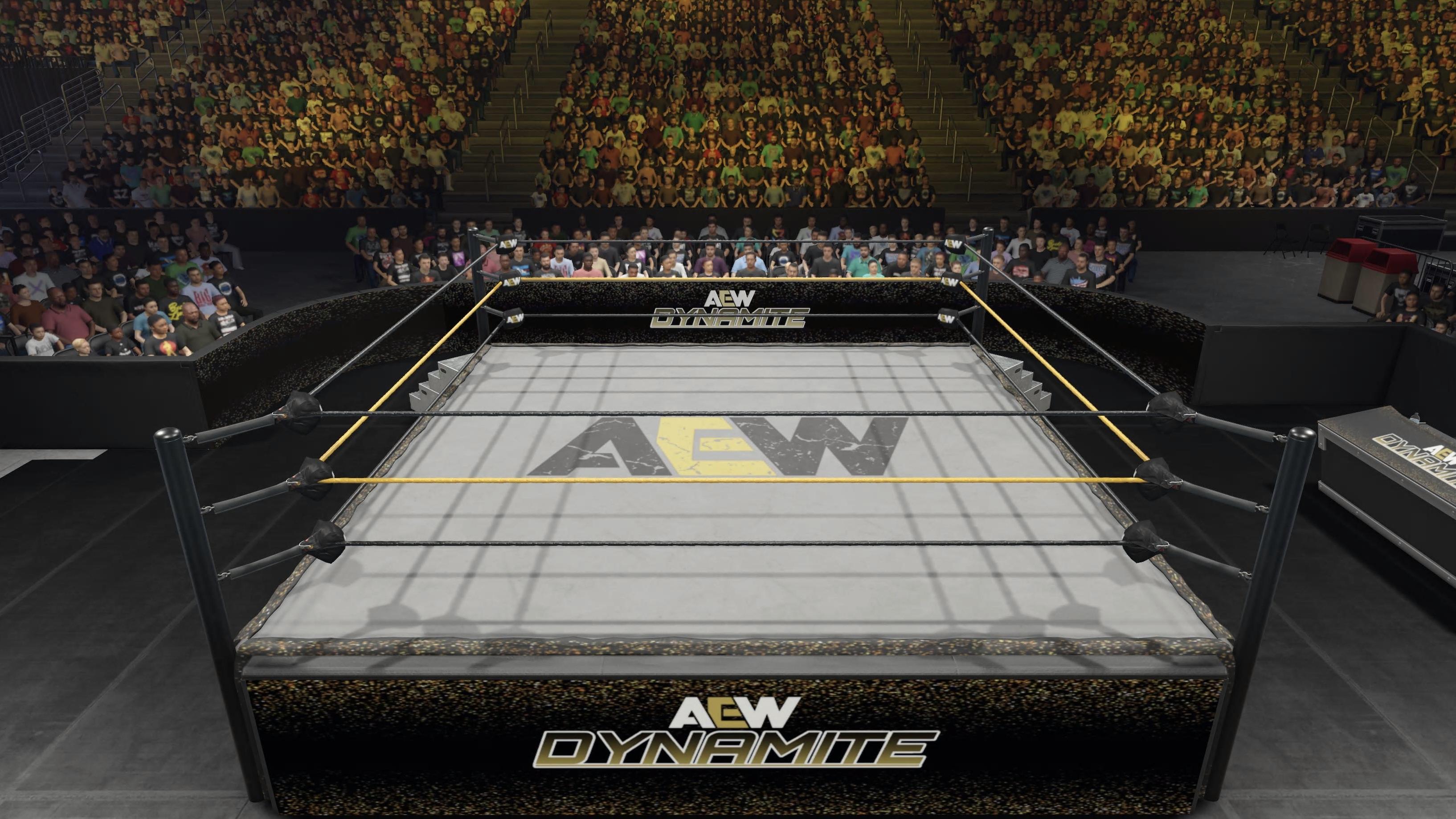 A wide shot of an AEW Dynamite wrestling ring inside a large arena during a main event, with bright overhead lights and fans holding up phones