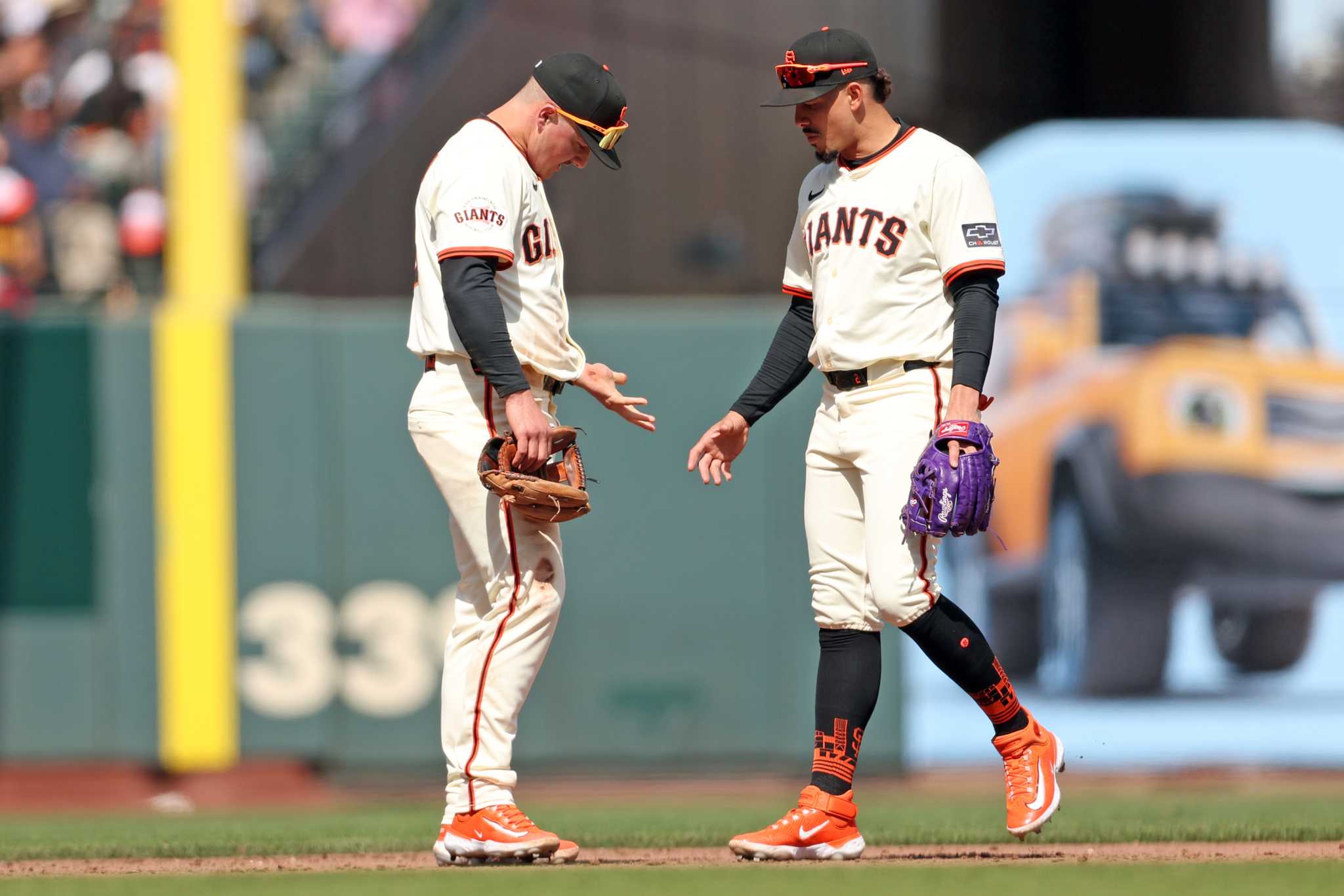 An MLB infielder ranging to his right and making a quick throw across his body during a daytime game, dirt flying as he plants his foot