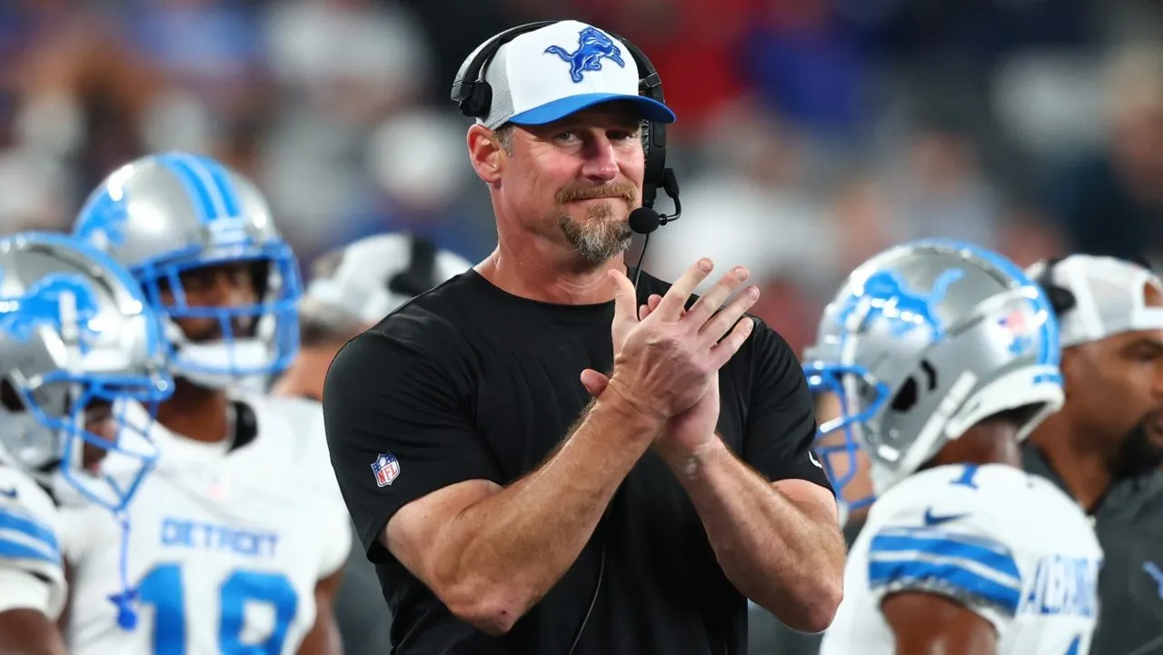 An NFL coach on the sideline holding a play sheet, echoing the article’s ‘coach reviewing film’ and ‘game script’ metaphors.