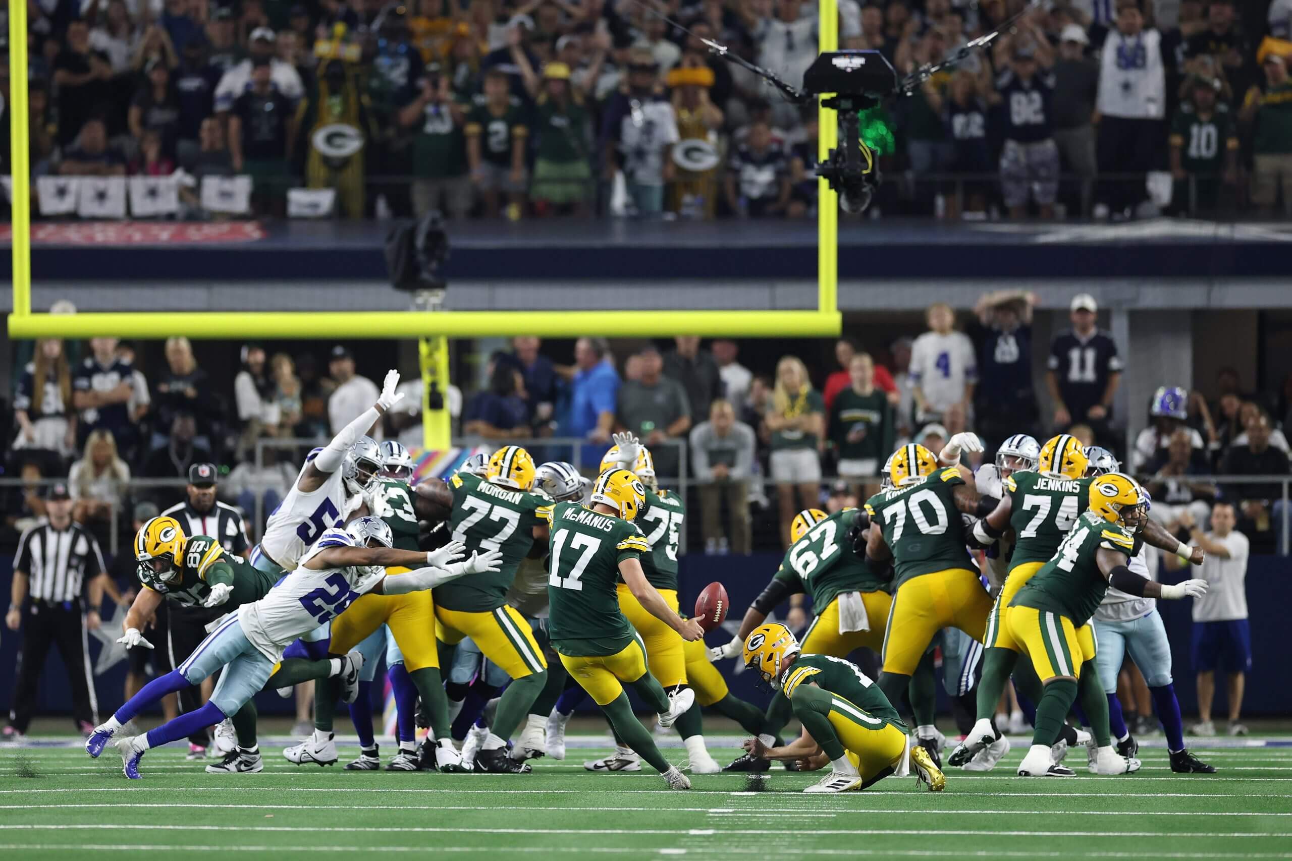 An NFL kicker attempting a field goal in overtime as linemen collide at the line of scrimmage and the ball rises toward the uprights