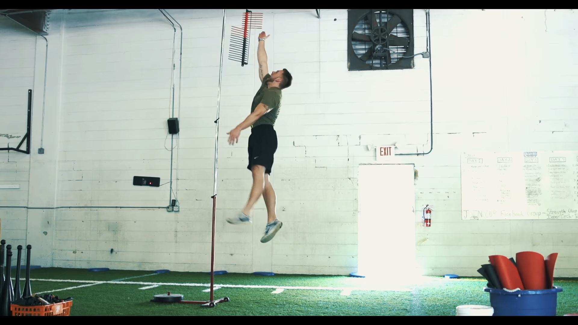 An athlete doing a dynamic warm-up with walking lunges on an indoor court, real photo