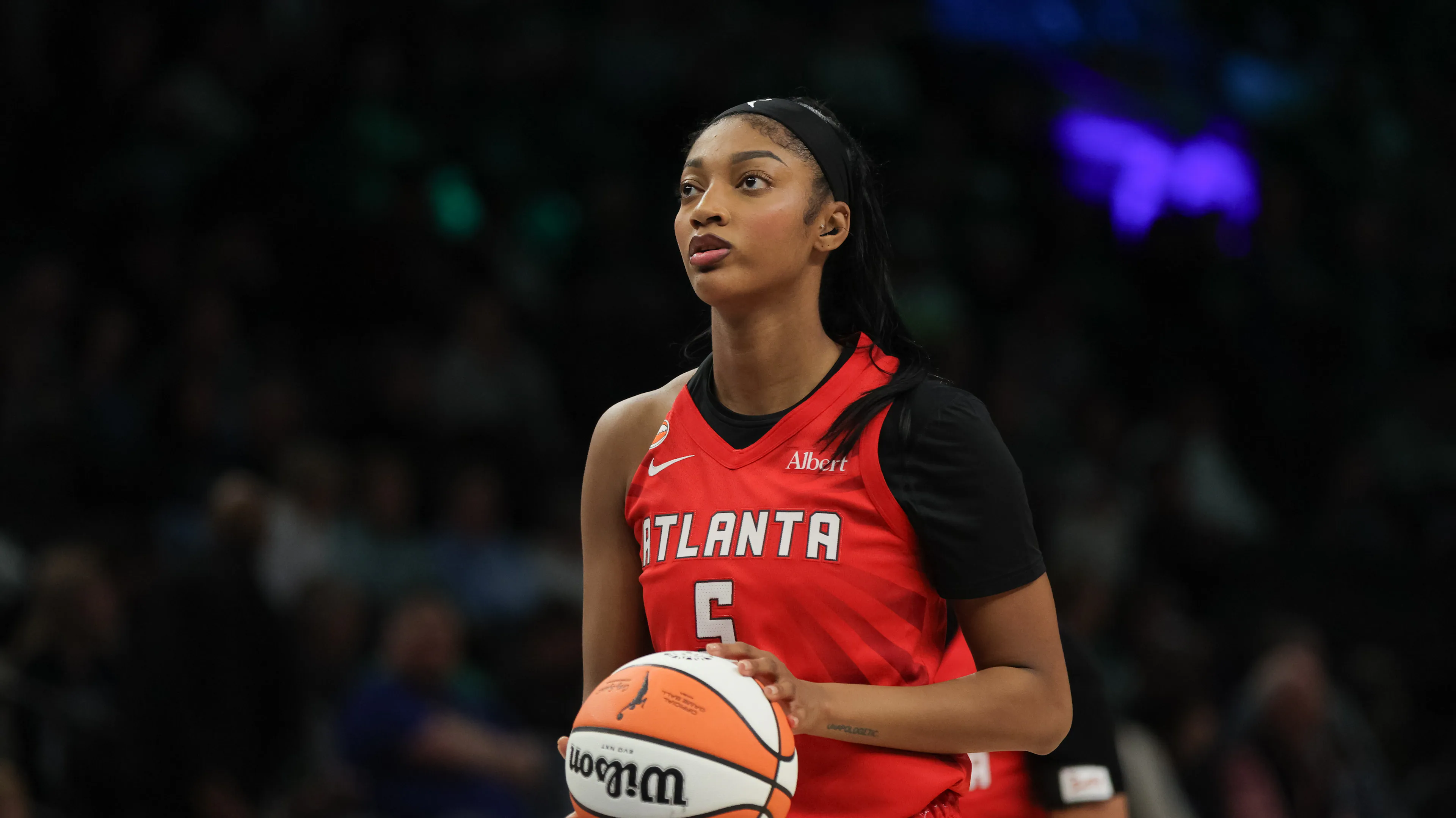 Angel Reese battles for a rebound in traffic during a WNBA playoff game, arms extended as multiple players contest the ball.