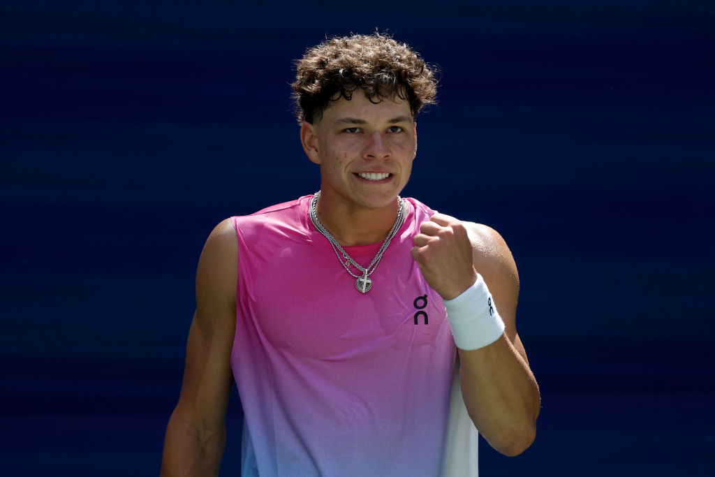 Ben Shelton competing at the 2024 US Open on a hard court, captured mid-serve with the stadium crowd behind him