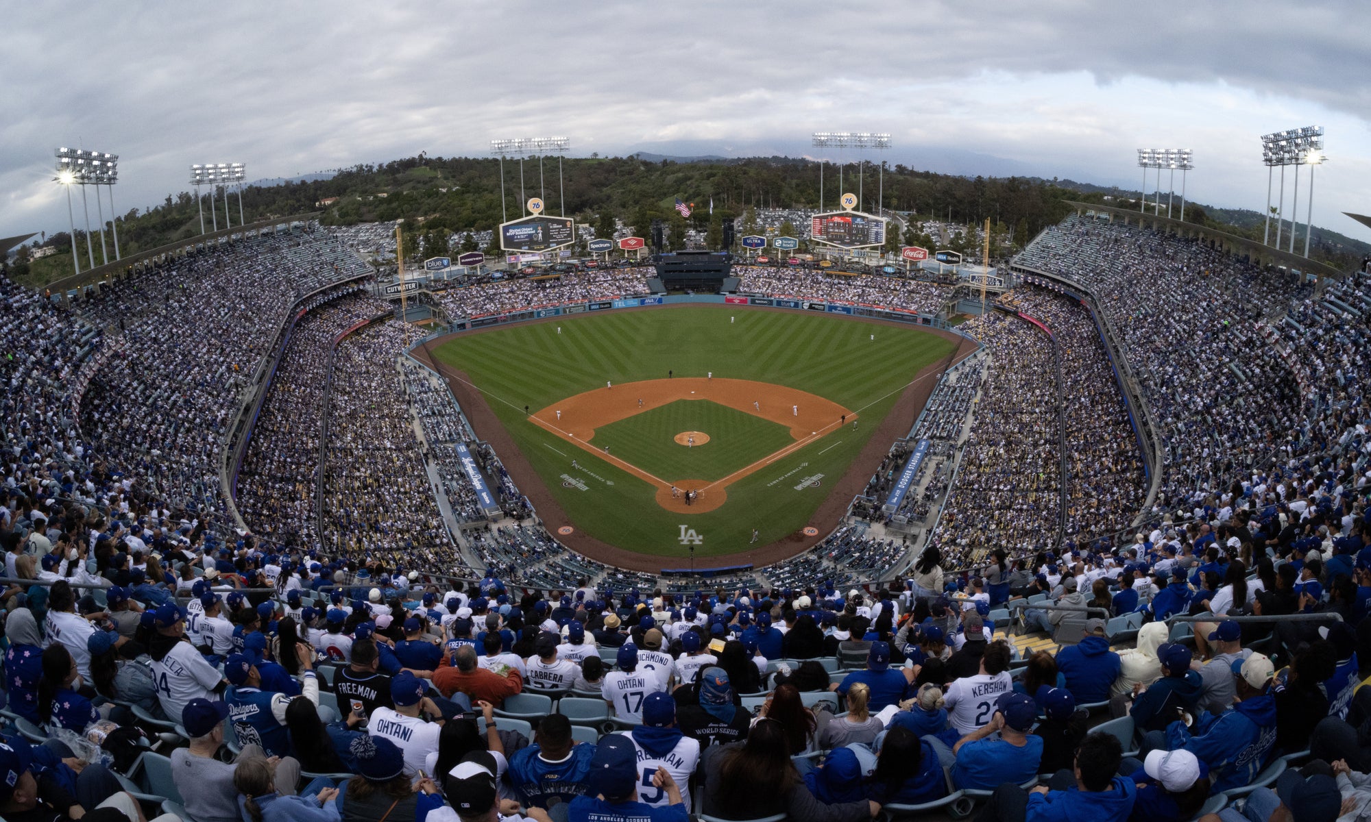 Dodger Stadium at night during a game with the field lit up and fans filling the stands
