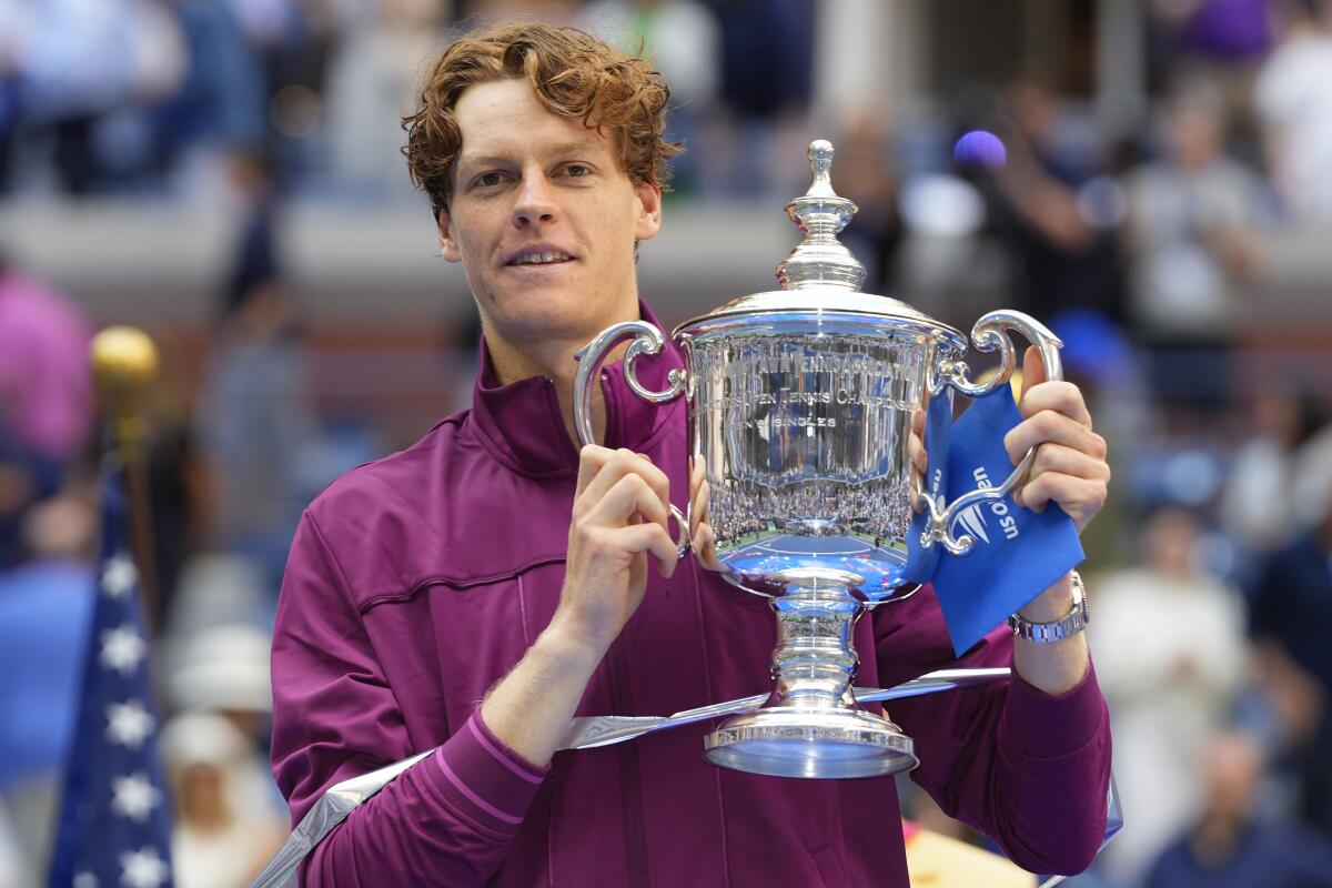 Jannik Sinner walking off a hard court carrying his tennis bag, looking subdued during a tournament week.