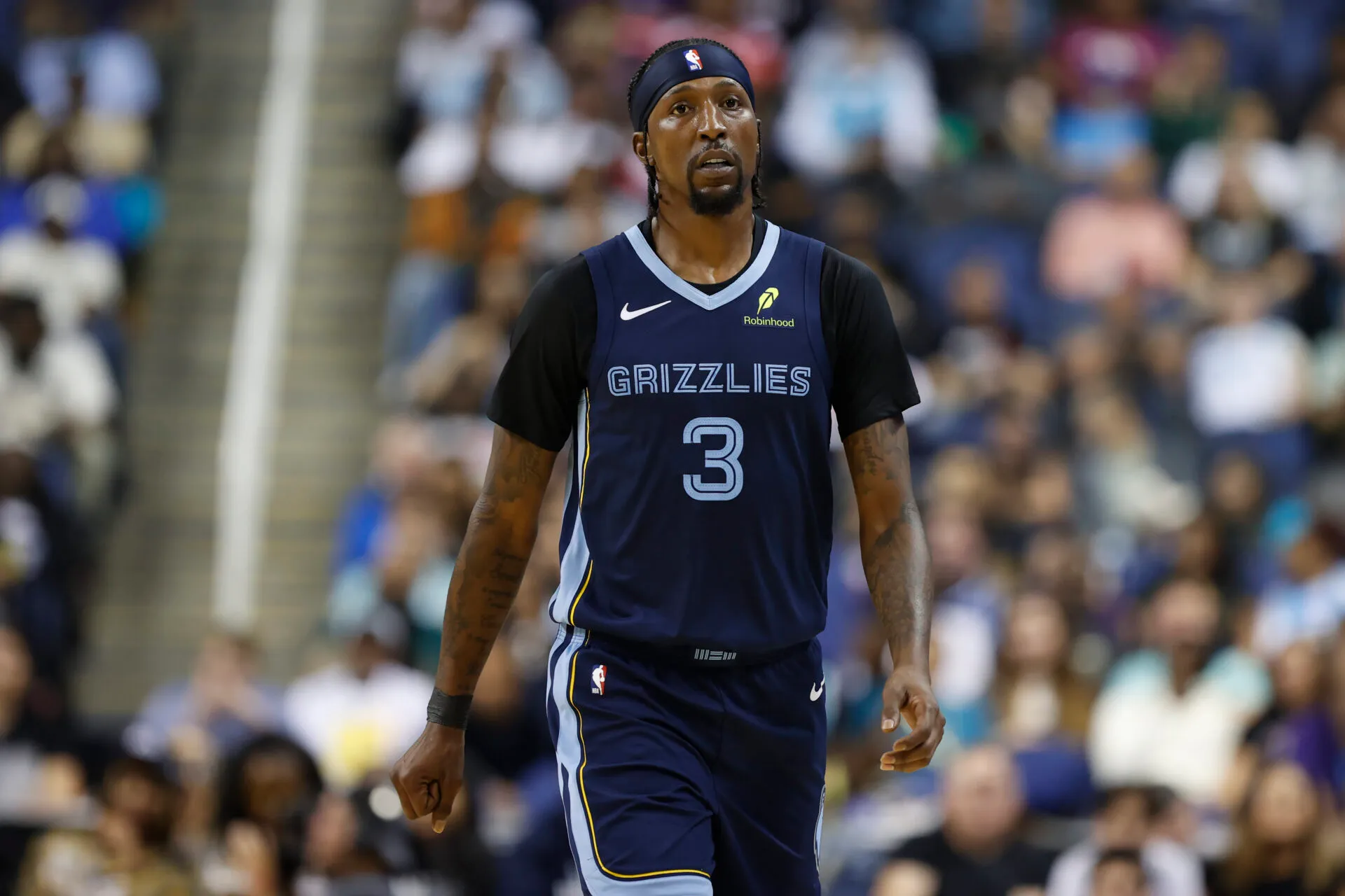 Kentavious Caldwell-Pope during an NBA game, standing on the perimeter ready to catch and shoot, arena lights and crowd in the background