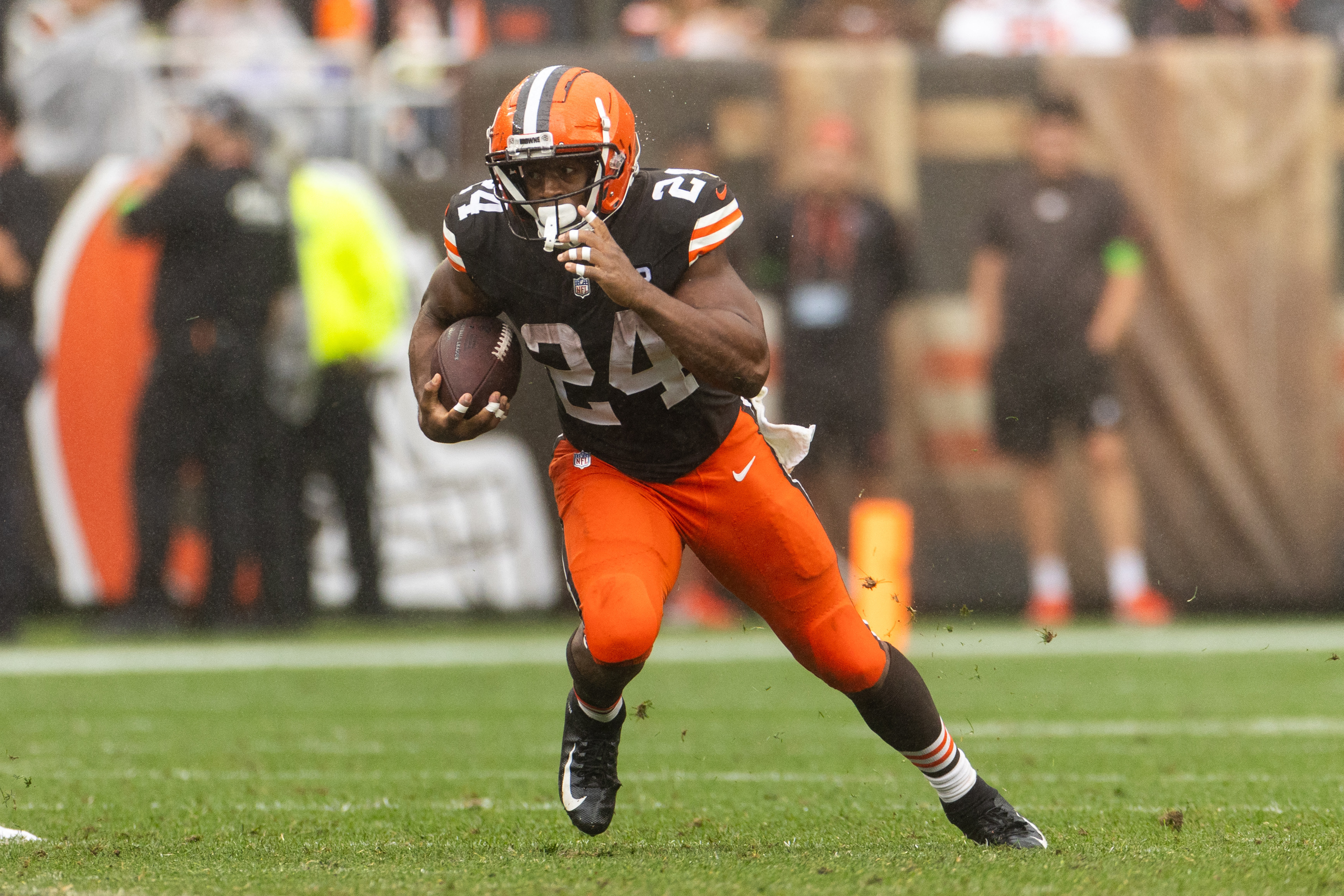 Nick Chubb in a Cleveland Browns uniform powering through a tackle attempt between the tackles as linemen engage at the line of scrimmage