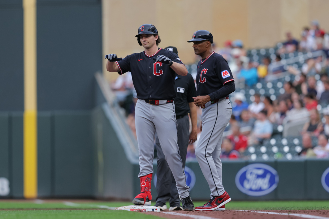 On-field action during a Minnesota Twins vs Cleveland Guardians game at Target Field, with a batter in the box and infielders set, nighttime stadium lighting
