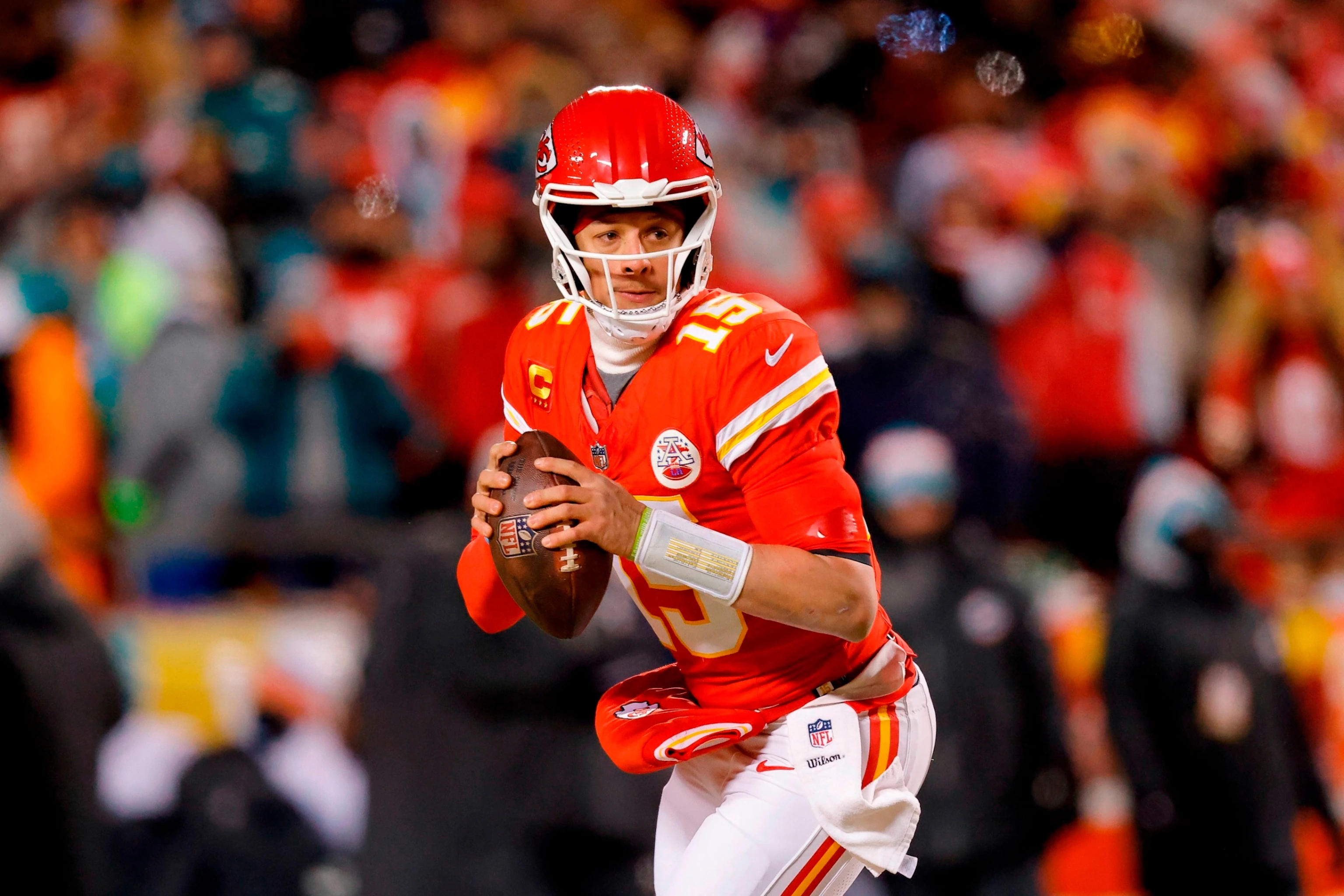 Patrick Mahomes dropping back to pass in a Kansas City Chiefs uniform with offensive linemen forming a pocket during game action