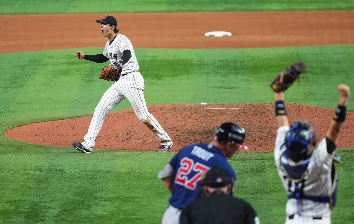 Shohei Ohtani on the mound facing Mike Trout in the ninth inning of the World Baseball Classic final as both teams watch from the dugouts