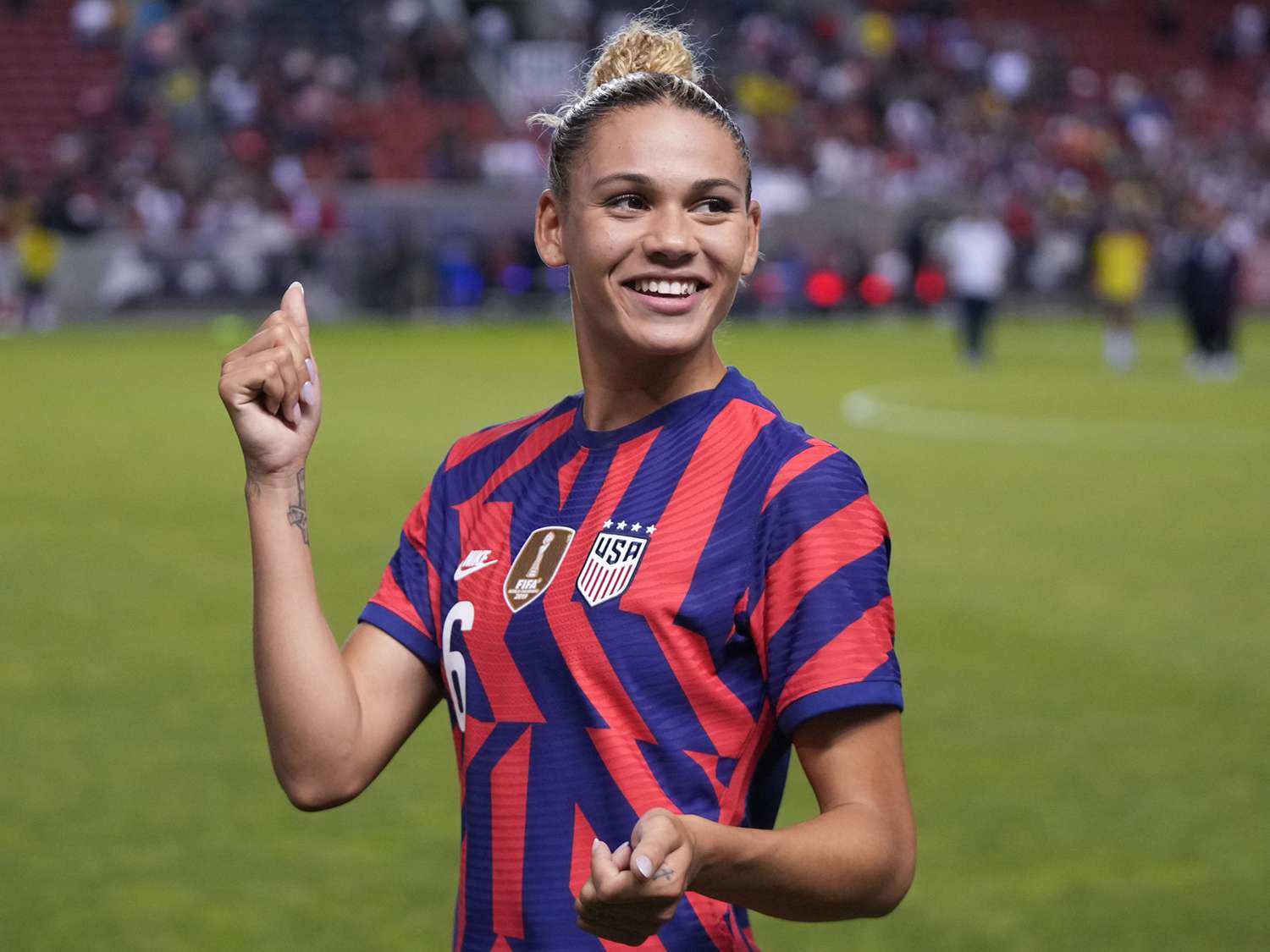 Trinity Rodman playing for the U.S. women’s national team in a competitive match, mid-stride with the ball at her feet as defenders close space